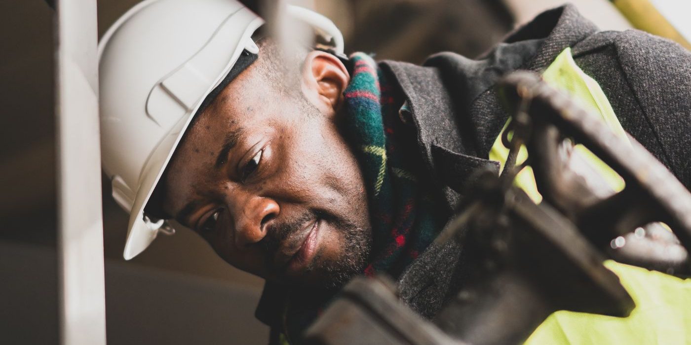Closeup Of A Man Working On Site Wearing A Hard Hat And Safety Vest
